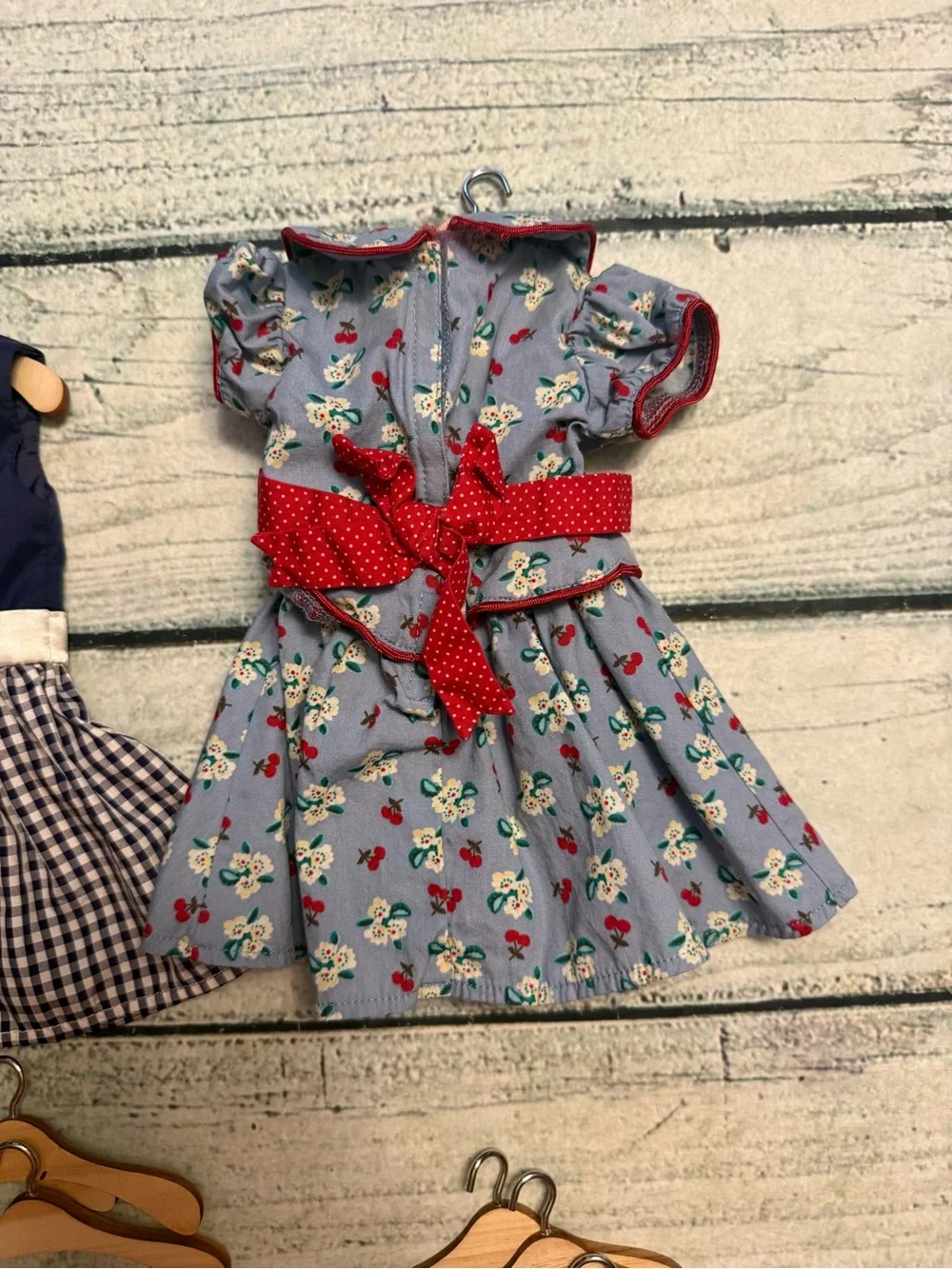 2 American girl doll dresses and 10 wood doll hangers.